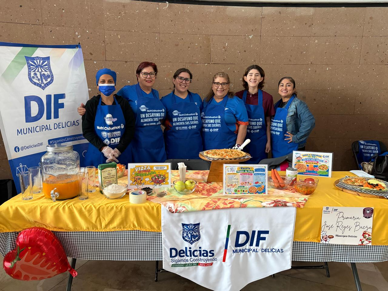 Madres de familia y personal del DIF Municipal de Delicias junto a la mesa del concurso de platillos