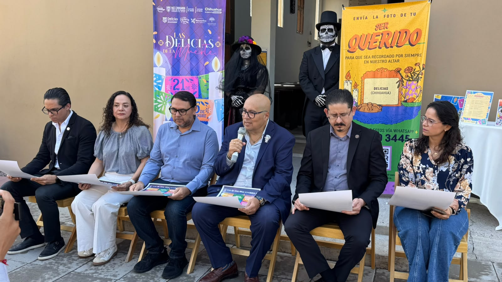 Participantes en una rueda de prensa frente a carteles del festival y dos personas caracterizadas de calaveras.
